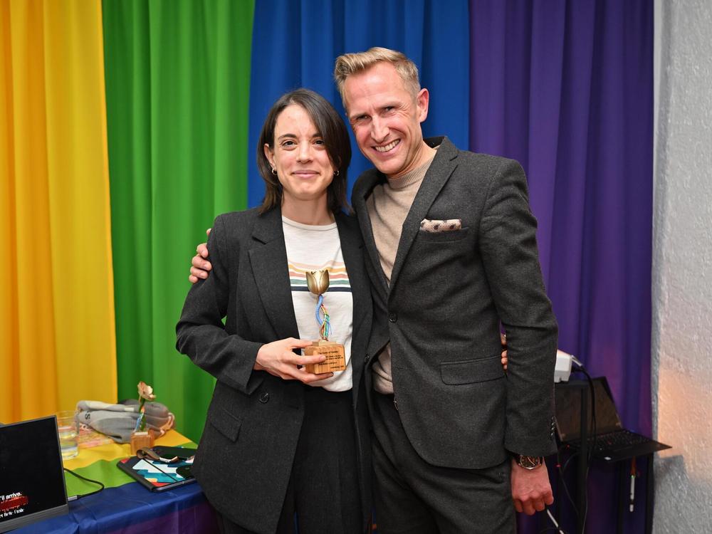 Isabel Spigarelli holding her flower trophy next to juror Jan Kayser
